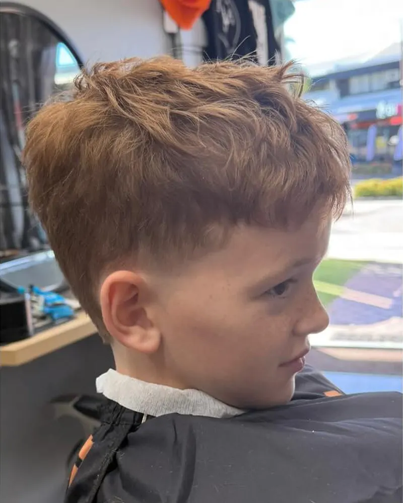 Boy's haircut with a taper fade, side view