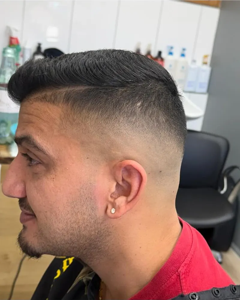 Mid fade with a slicked, side-swept top cut at Airlie Cutz in Airlie Beach